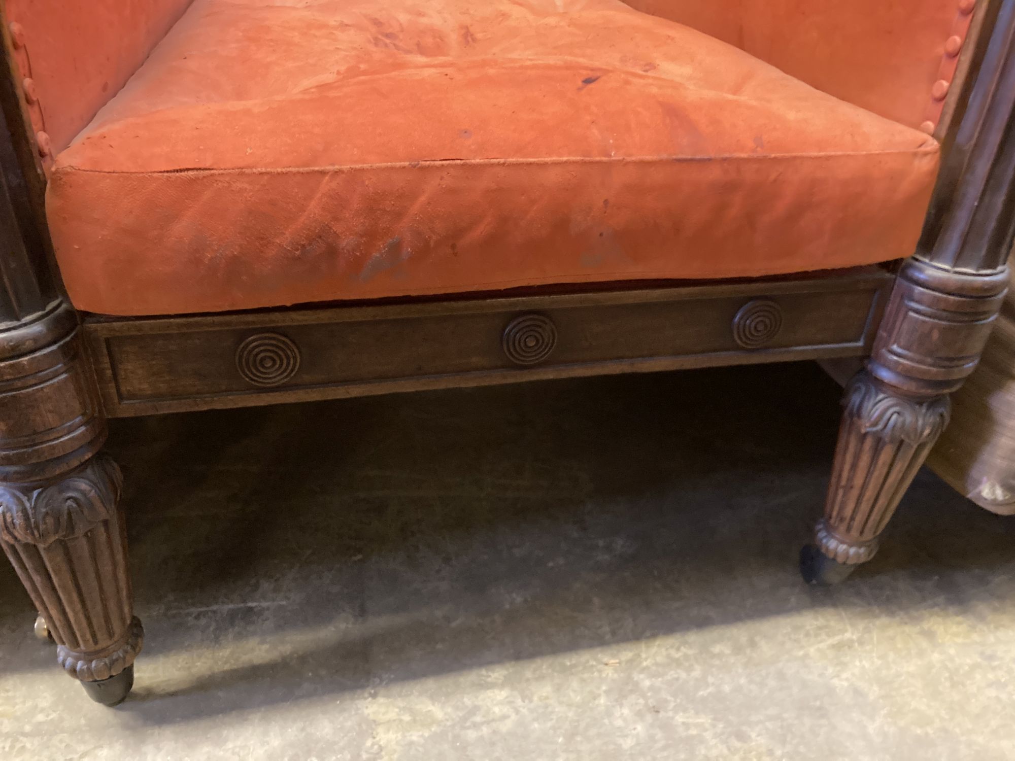 A George IV carved mahogany library armchair upholstered in faded red leather, width 70cm, depth 80cm, height 100cm